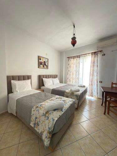 a bedroom with two beds and a table at The Rock Apartments in Himare