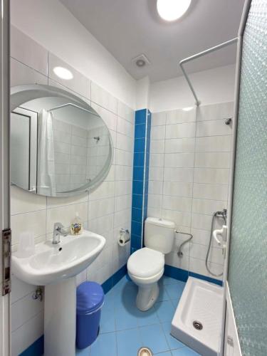 a bathroom with a sink and a toilet and a mirror at The Rock Apartments in Himare