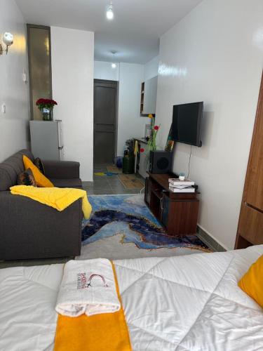 a living room with a bed and a tv at Tsavo in Kiambu
