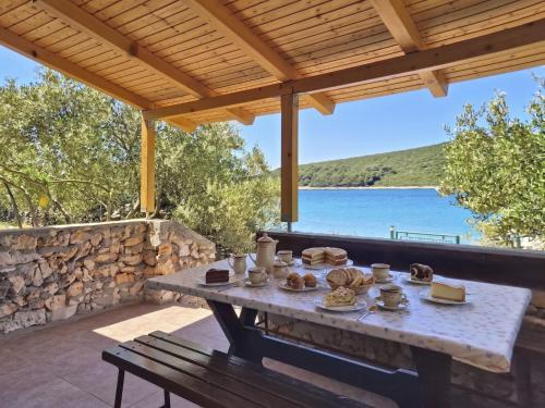 a picnic table on a patio with a view of the water at Holiday Home Rudi by Interhome in Kraj