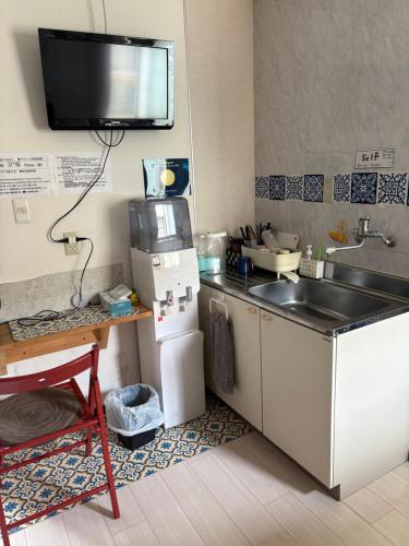 a small kitchen with a sink and a refrigerator at Yasuragi Nakasu in Fukuoka