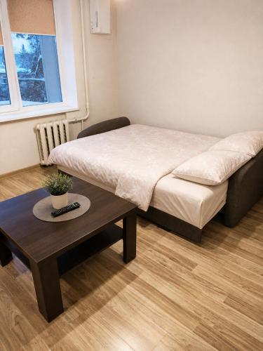 a small bedroom with a bed and a coffee table at Nemunas in Panevėžys