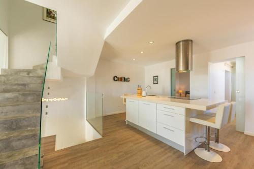a kitchen with white cabinets and a glass wall at Caracolas Luxury House Duplex in Tarifa