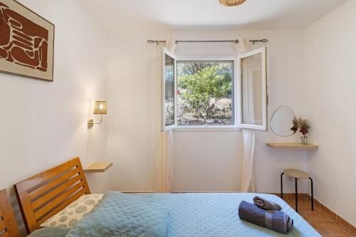 a bedroom with a bed and a window at Limbarto - Gîte climatisé au calme in Serra-di-Ferro