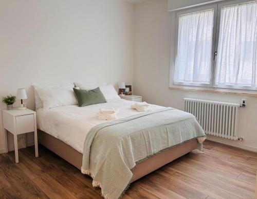 a white bedroom with a bed and a window at Bassano Sweet Home in Bassano del Grappa