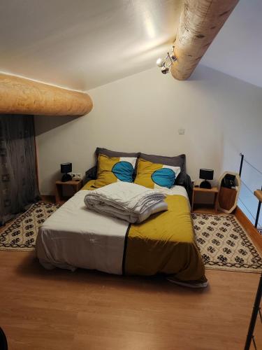 a bedroom with a bed with yellow and blue pillows at Maison individuelle, au calme in Visan