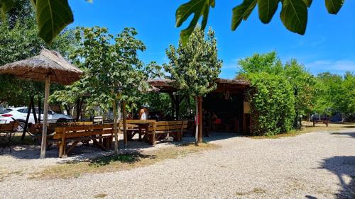 a restaurant with benches and umbrellas in a park at Marina Park Camping in Vama Veche