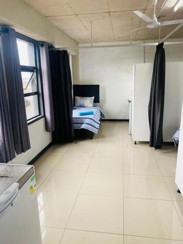 a room with a bed and a refrigerator in it at Heavens stay in Vosburg
