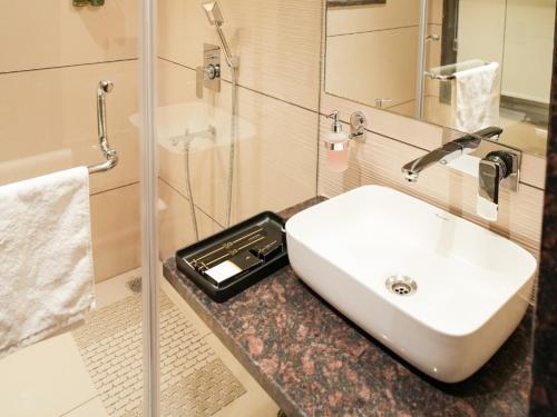 a bathroom with a sink and a glass shower at Velora The Luxury Resort in Māndu