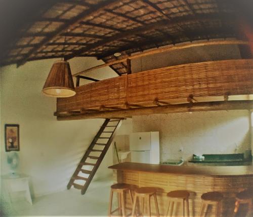 Cama elevada en habitación con bar y taburetes en Sossego de Jaua en Camaçari