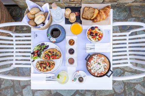 a table full of food on a white table at Casa Nina in Patitiri