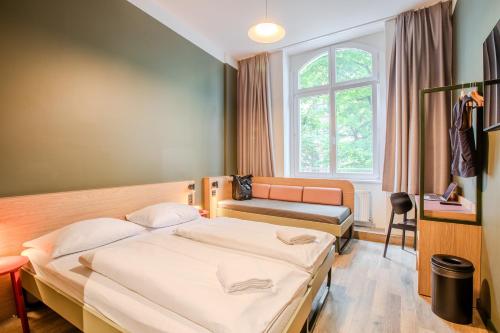 a hotel room with a bed and a window at MEININGER Hotel Berlin Mitte in Berlin