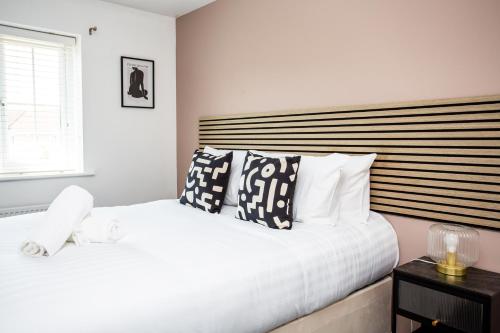 a bedroom with a white bed with a wooden headboard at Arkless Grove FREE Parking WiFi in Black Hill