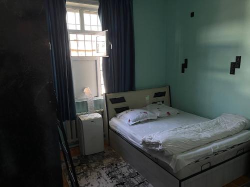 a small bed in a room with a window at Central Hostel in Tashkent