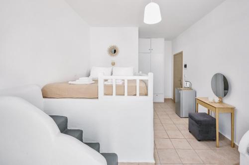 a white bedroom with a bed and a bathroom at White island rooms in Panteli