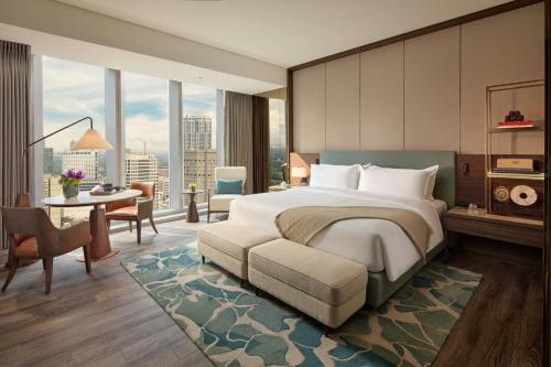 a hotel room with a bed and a desk and a room at Mandarin Oriental Makati, Manila in Manila
