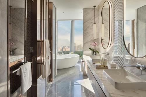 a bathroom with two sinks and a tub at Mandarin Oriental Makati, Manila in Manila