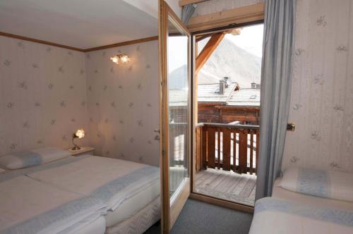 a bedroom with two beds and a balcony at La Locanda in Livigno