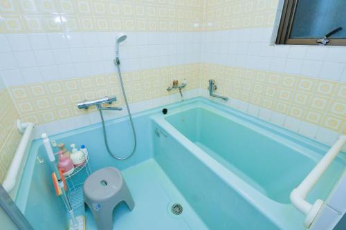 a bathroom with a blue tub and a toilet at Re-home in Izunokuni