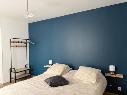 a bedroom with a blue wall and a bed at L'Opaline - Bord de Seine près de Giverny in Vernon