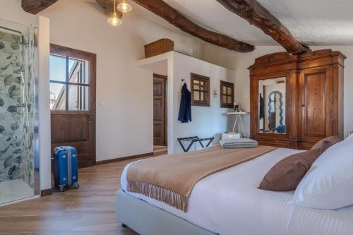a bedroom with a large bed with a wooden cabinet at Palazzo Brighenti in Pozzolengo