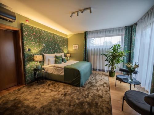 a bedroom with a bed with a green wall at Platán Villa - Platán Tata in Tata