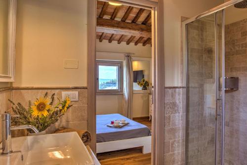 a bathroom with a shower and a bed in a room at CASALE DEI GELSOMINI 8, Emma Villas in Todi