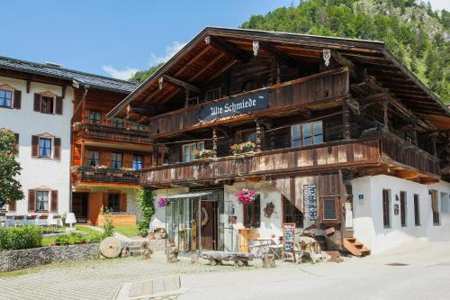 a large wooden building in front of a mountain at Hotel Oberschmied in Reit im Winkl