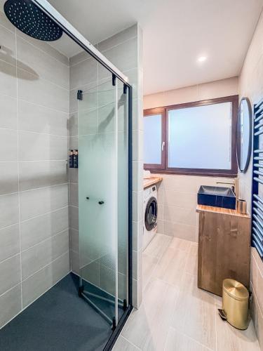 a glass shower in a bathroom with a washing machine at Les Caribous - Lac 1 min, Espace Diamant, Megeve in Praz-sur-Arly