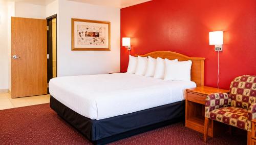 a hotel room with a bed and a chair at Tava Motel Manitou Springs in Manitou Springs