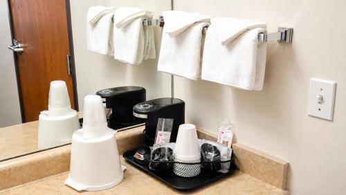 a bathroom vanity with a mirror and towels at Tava Motel Manitou Springs in Manitou Springs
