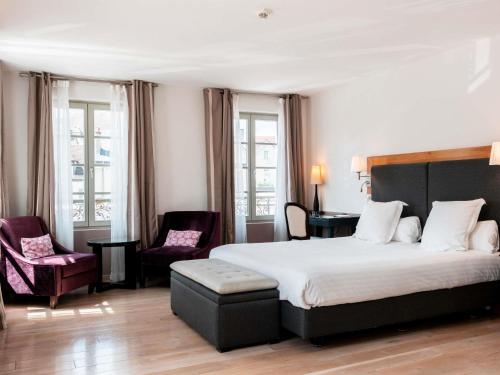 a hotel room with a bed and two chairs at Mercure Maintenon in Maintenon