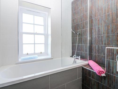 a bathroom with a bath tub and a window at Meadowgreen Farmhouse in Forfar