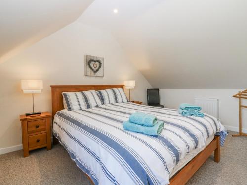 a bedroom with a bed with blue towels on it at Meadowgreen Farmhouse in Forfar