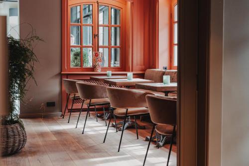 a row of tables and chairs in a room with windows at Tides Boutique Hotel in Norden
