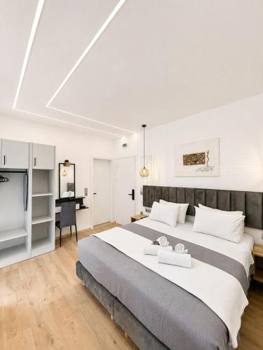 a bedroom with a large bed and a desk at Nefonas Guest House in Skiathos