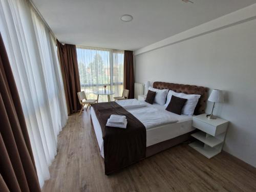 a bedroom with a large bed and a large window at Gartenhotel Altmannsdorf in Vienna