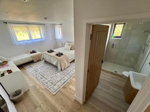 a bedroom with two beds and a bathroom with a sink at Pourquoi Pas B&B in Sark