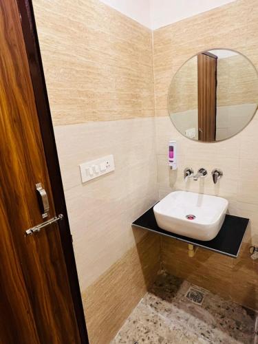 a bathroom with a sink and a mirror at Mount Green Hotel Bharatgarh in Bharatgarh
