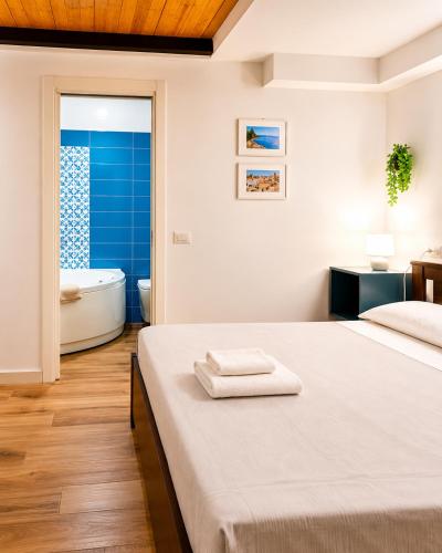 a bedroom with a bed and a bathroom with a tub at Rega Holiday House in Naples