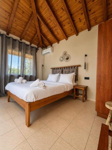 a bedroom with a large bed with a wooden ceiling at Sergios in Koukounaries