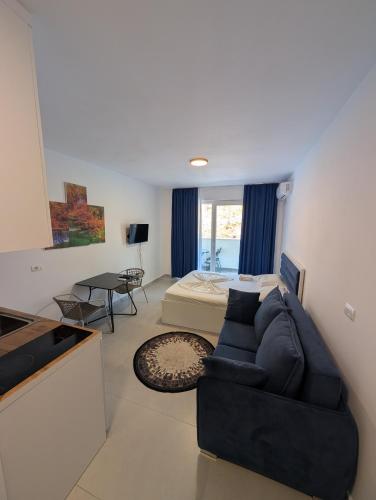 a living room with a couch and a bed at Studio apartment LISI 2 in Lezhë