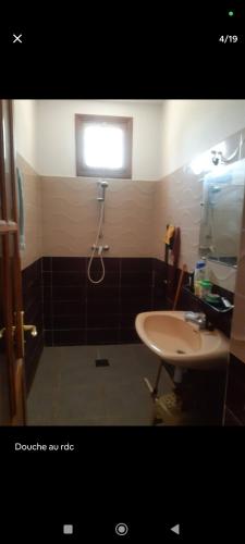 a bathroom with a sink and a shower and a window at Dar ojkak in Essaouira