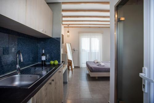a kitchen with a sink and a bed in a room at Alexander Studios & Suites - Adults Only in Faliraki