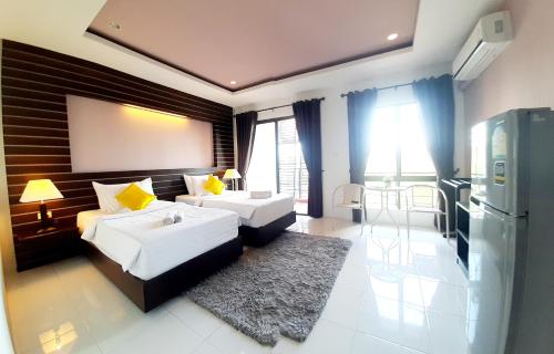 a living room with two beds and a kitchen at Purimas Resortel in Rawai Beach