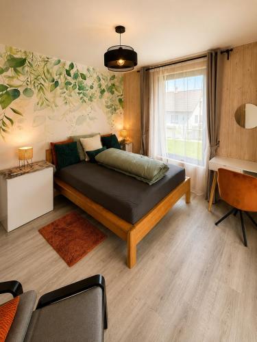 a bedroom with a bed and a desk and a window at Modern House with Private Pool & Terrace in Červená Třemešná
