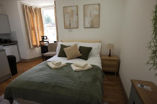a bedroom with a bed with two towels on it at Deaf Property - Woolwich Elizabeth Line Studios in Woolwich