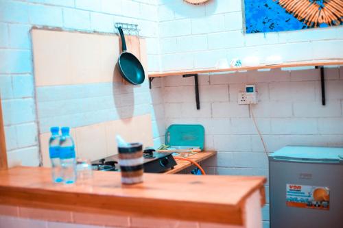 a kitchen with a table and a pot on the wall at Meleji House in Arusha