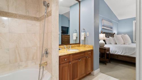 a bathroom with a shower and a sink and a tub at 907 Mariners Club in Key Largo