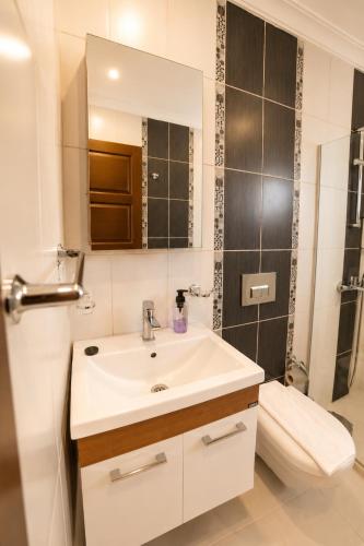 a bathroom with a sink and a toilet and a mirror at Villa Yagmur in Kalkan